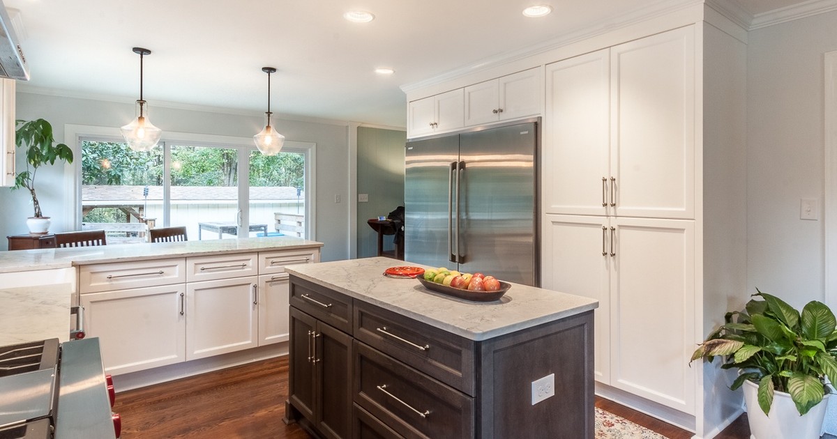 White kitchen with wood island, hardwood floors, and professional range in Charlotte.
