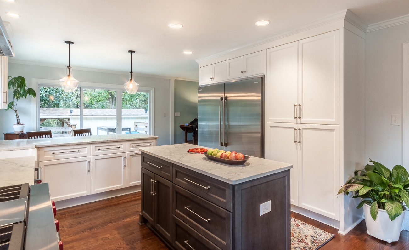 kitchen remodel with dark wood island white cabinetry stainless steel refrigerator and quartz countertops in charlotte nc