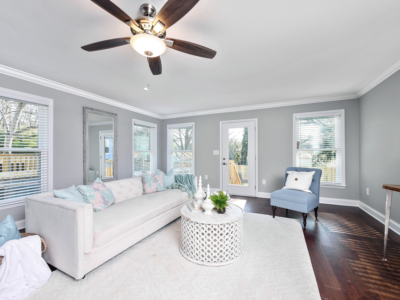 bright living room with white sofa blue chair and dark hardwood floors in a charlotte nc home addition