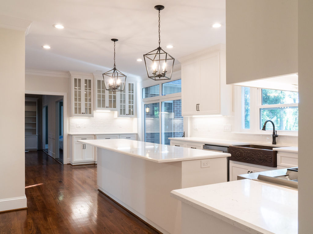 bright white kitchen with island farmhouse sink and pendant lights in a whole home remodel in charlotte nc