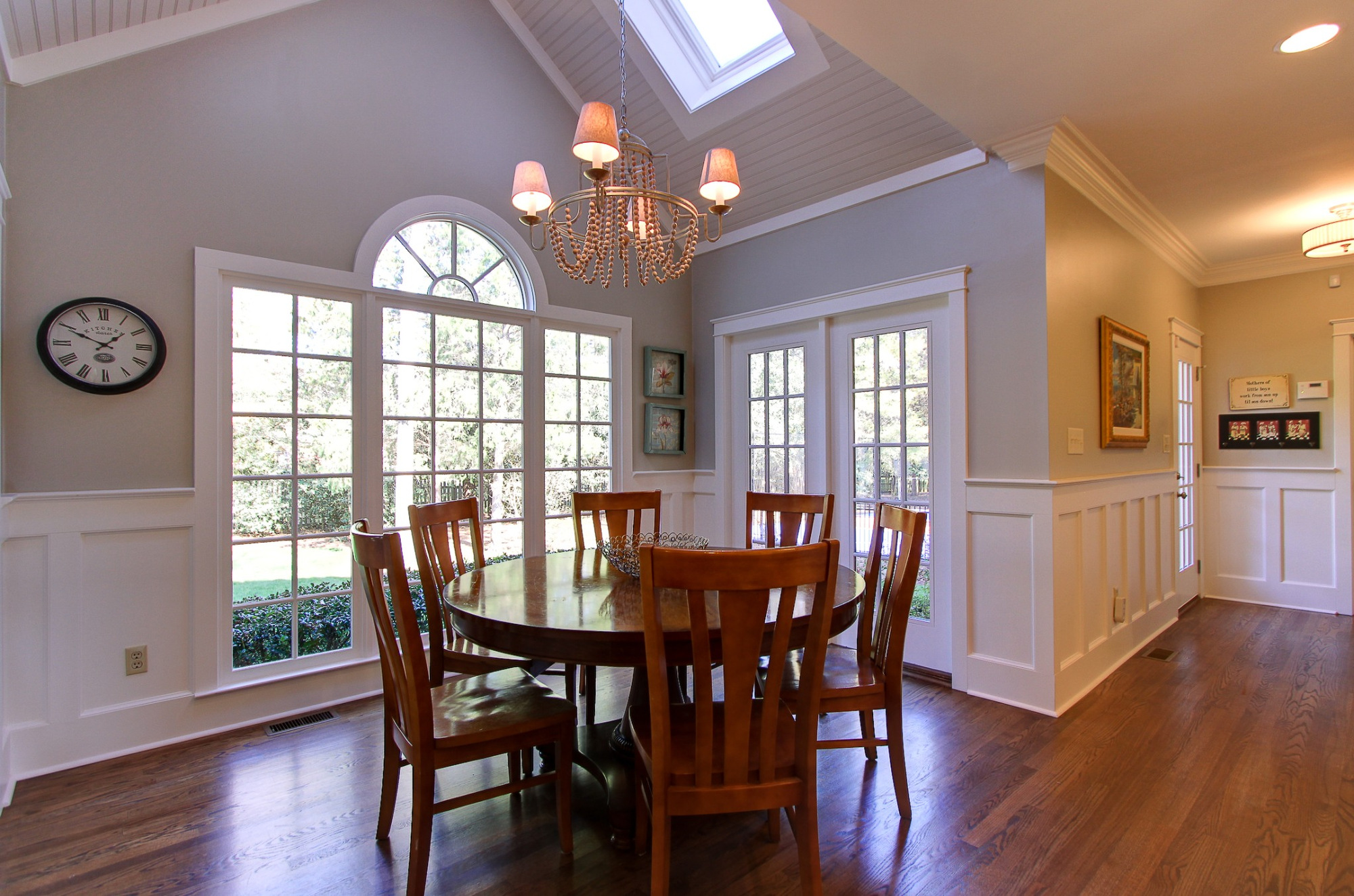 whole home remodel bright dining room with vaulted ceiling large windows and white wainscoting in charlotte nc