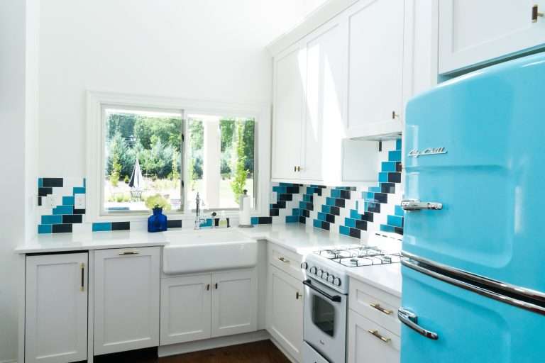 remodeled kitchen with custom tile work by 7 Acre construction and bright blue refrigerator