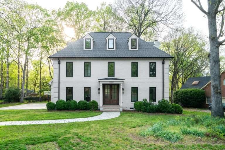 white brick single family colonial style home