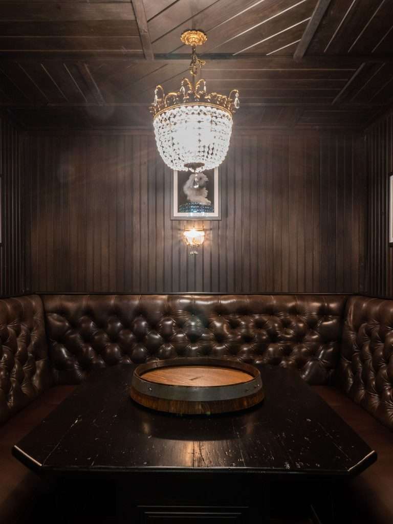 elegant room addition with crystal light and wood paneled walls by 7 Acre Construction