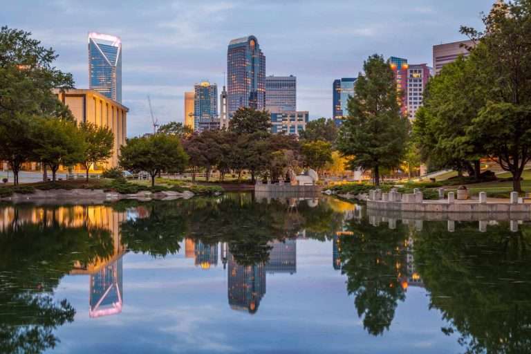 view of Charlotte, NC with water and trees in the front