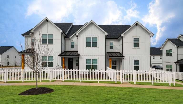 group of three attached homes with white siding and fencing